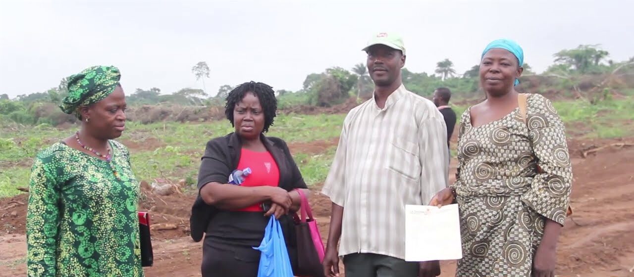 Buyers on their allocated land at Lashone Estate, Ikorodu, one holding an allocation letter